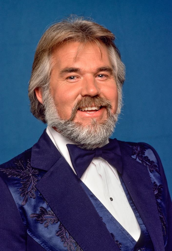 Kenny smiling a navy suit 