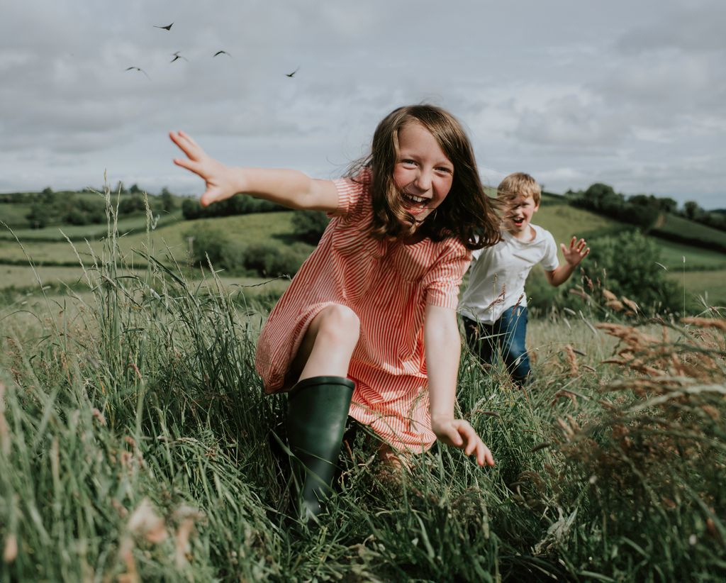 Fille et garçon coulant dans le champ de l'herbe