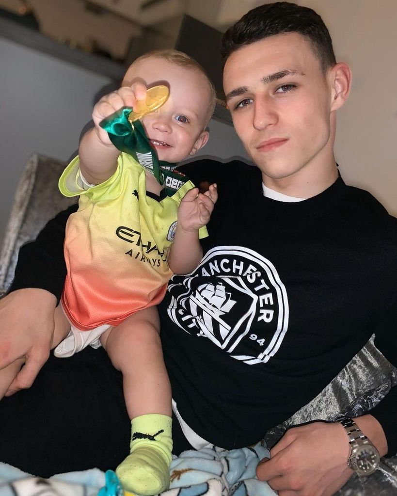 Phil Foden with his son wearing his medal