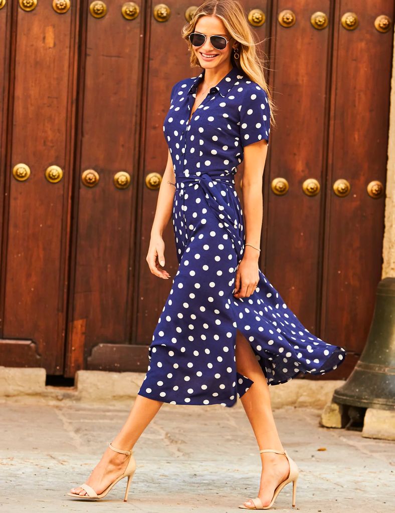 Model wears blue polka dot sosandar dress