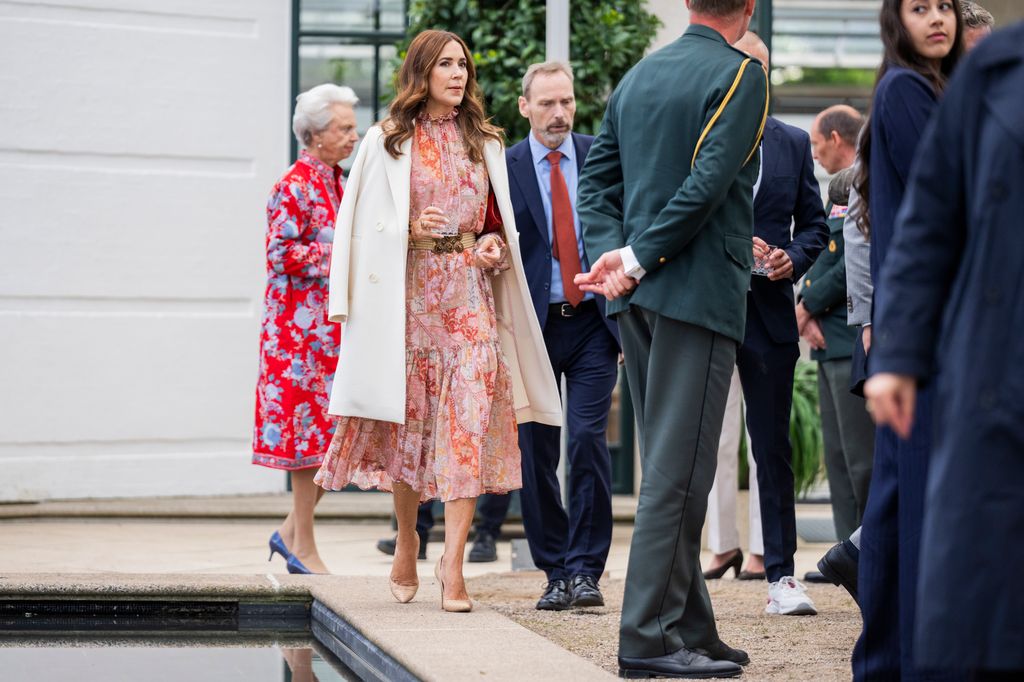 Queen Mary in a Zimmermann dress with a white coat