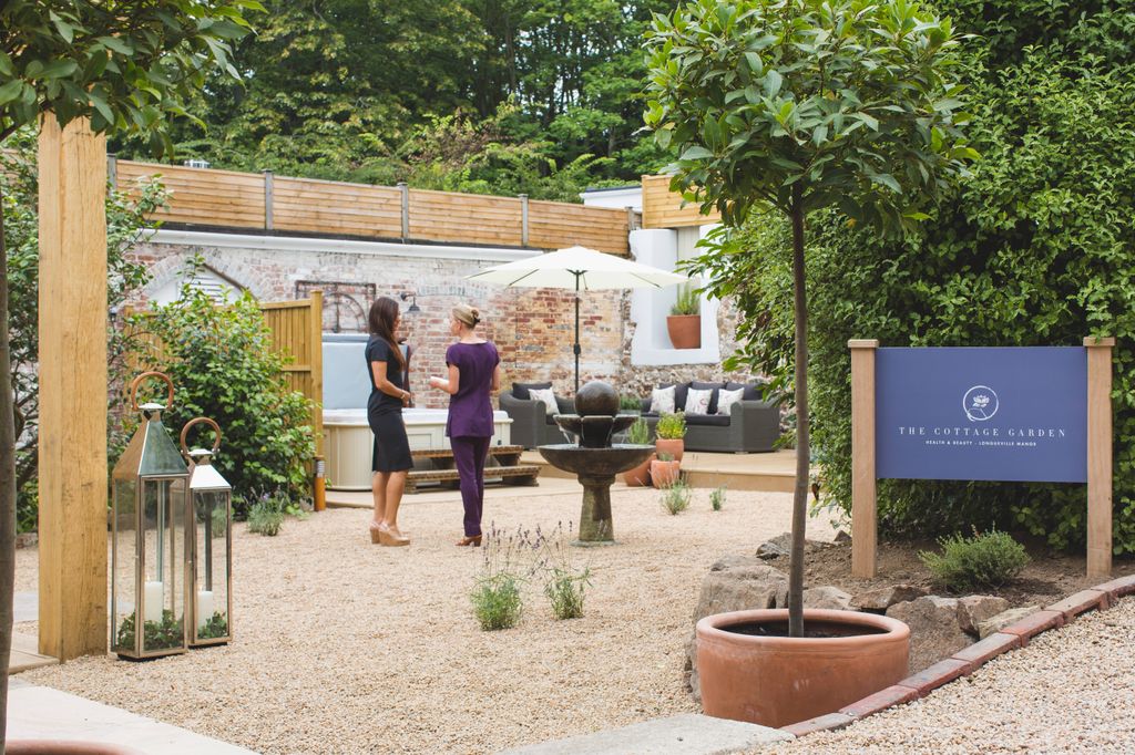 Walled courtyard spa girded by trees with two ladies talking 
