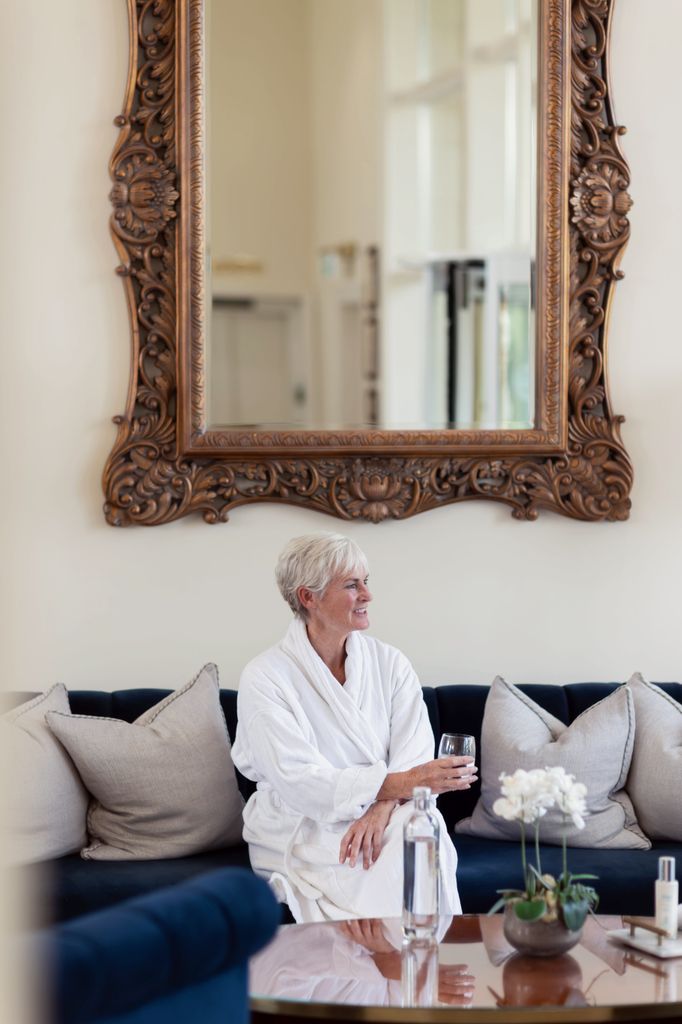 Judy Murray wearing a robe on a plush sofa