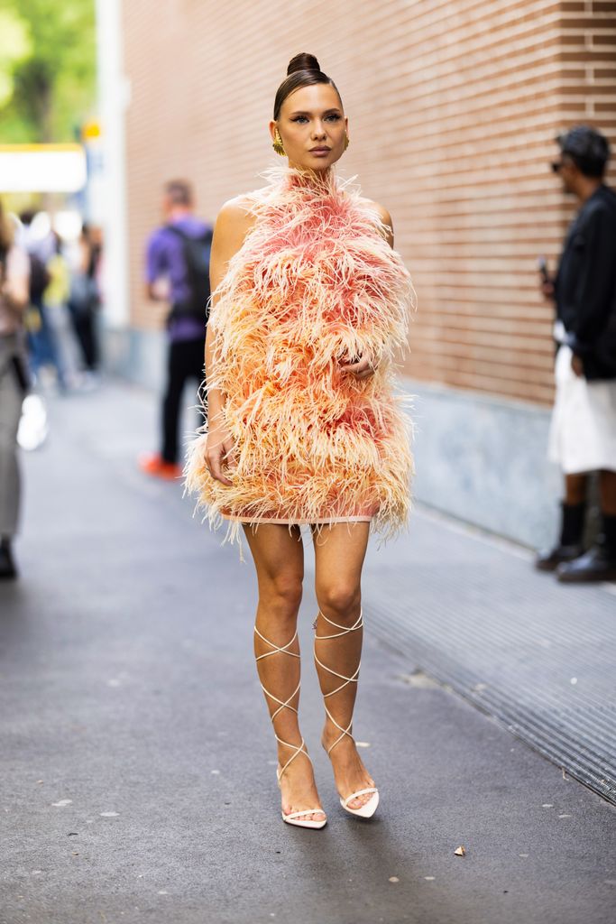 MILAN, ITALY - SEPTEMBER 20: A guest is seen wearing a feather orange dress outside the Fendi show during Milan Fashion Week Womenswear Spring/Summer 2024 on September 20, 2023 in Milan, Italy. (Photo by Valentina Frugiuele/Getty Images)