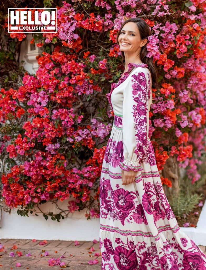 Veronica Schmidt in floral dress by pink and red floral wall outside Marbella home