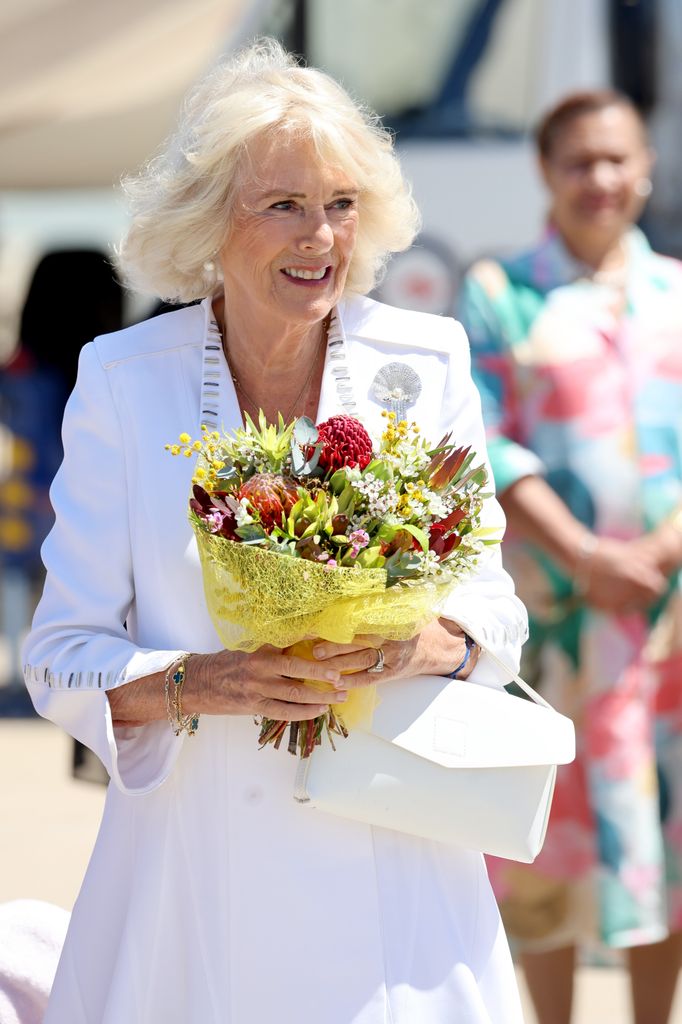 Queen Camilla receives flowers upon arrival 