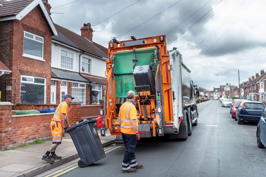 Refuse collectors and refuse truck in street
