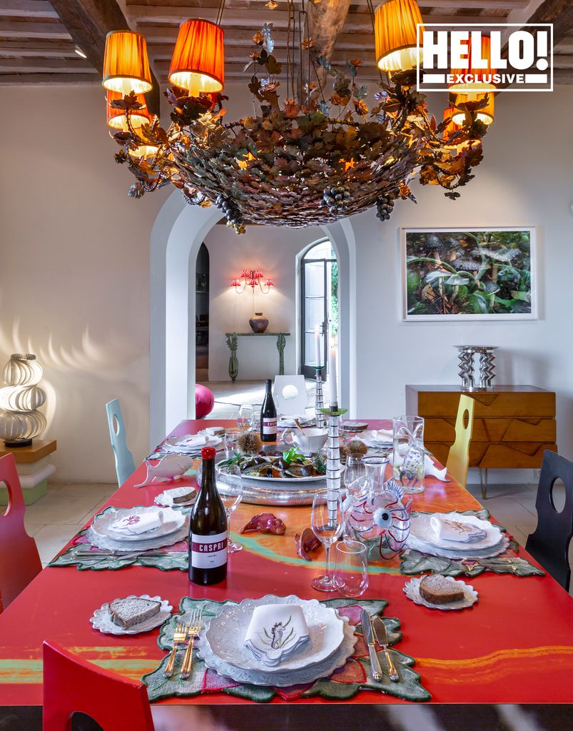 Suzanne Syz dining table with quirky chandelier and red tablecloth