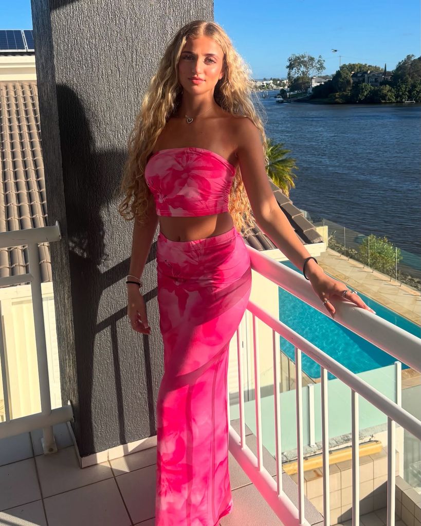 princess andre in pink outift posing on balcony 