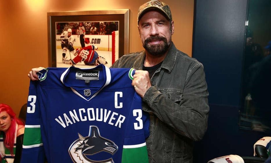 Actor John Travolta holds a Vancouver Canucks jersey during the NHL News  Photo - Getty Images