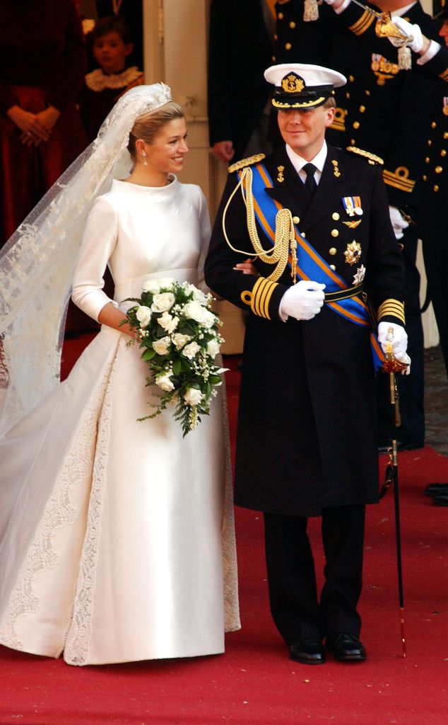 Willem Alexander em uniforme militar de braços dados com sua nova noiva Maxima no dia do casamento em 2002