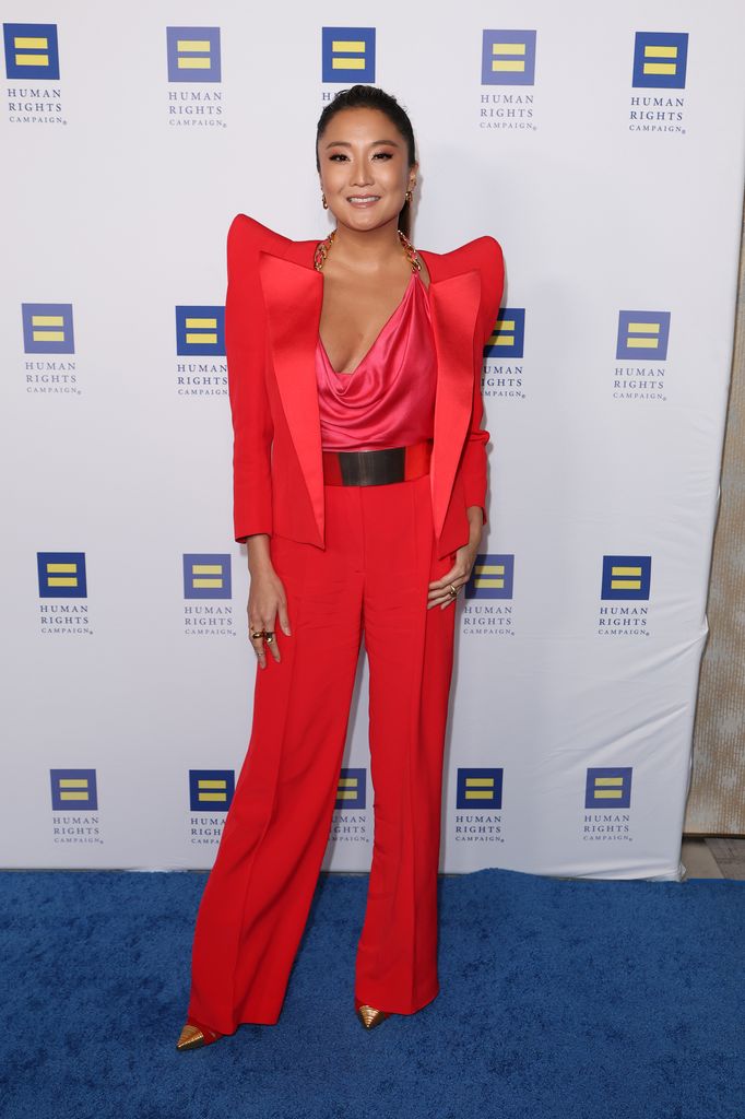 Ashley Park on blue carpet in coral suit