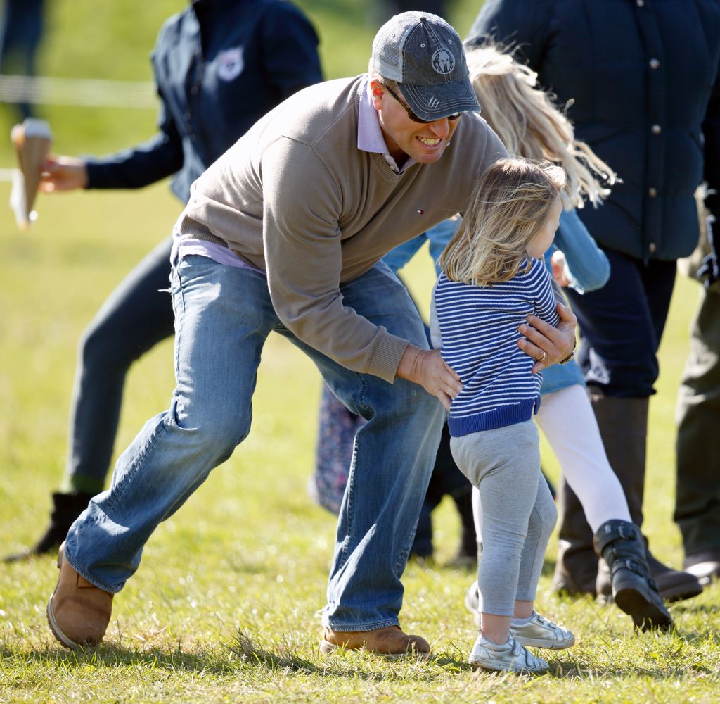 Peter Phillips plays with his niece Mia Tindall as they attend the Gatcombe Horse Trials at Gatcombe Park