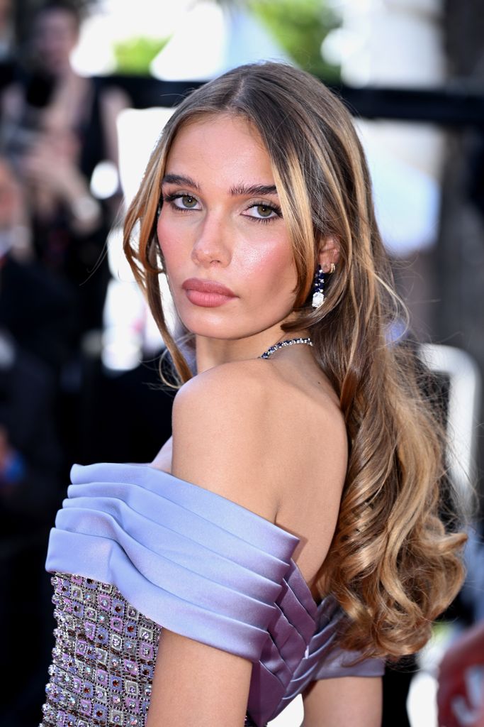Hana Cross wears loose waves and a rosy pink lip to the 77th Cannes Film Festival 