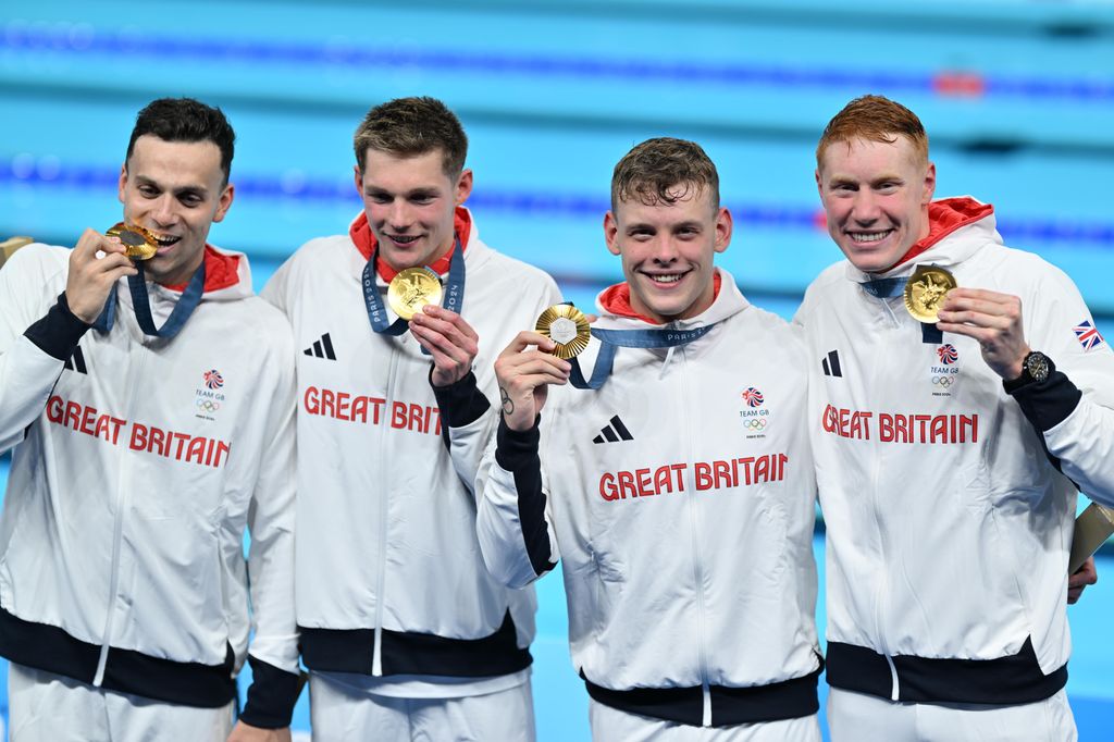 Tom Dean, Duncan Scott, Matthew Richards and James Guy of Great Britain Team celebrate after winning gold in the Men's 4x200m Freestyle Relay Final