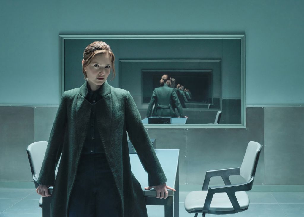 woman leaning against table in interrogation room