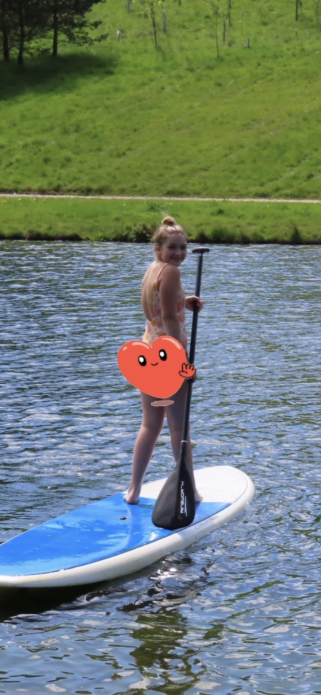 Harper Beckham paddleboarding on a lake