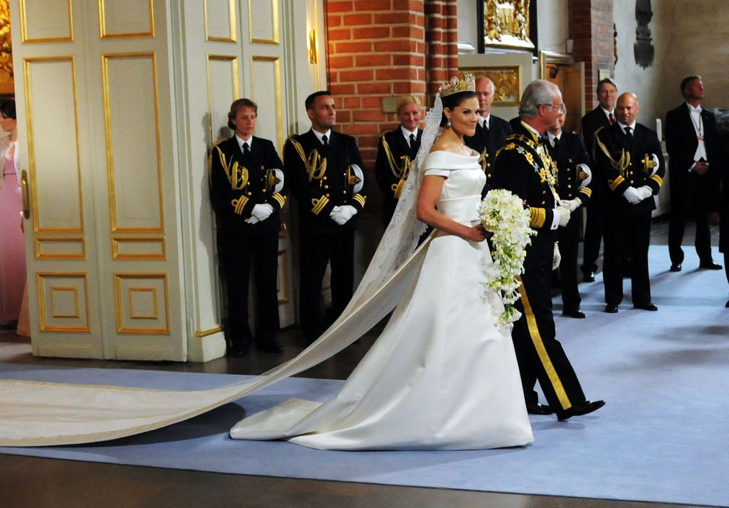 Crown Princess Victoria of Sweden is led into the church by her father the King Carl Gustaf