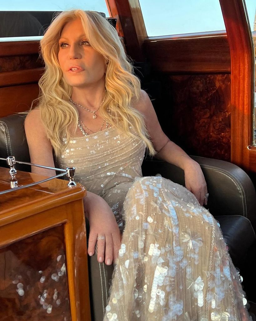 Donatella Versace in sparkly dress on a boat looking into the distance