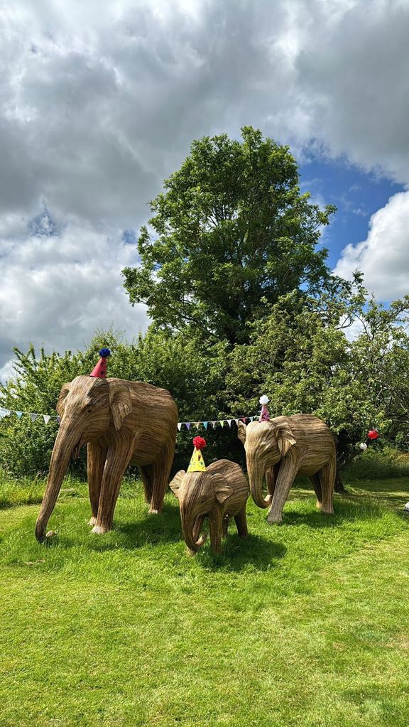 A photo of elephant statues wearing party hats