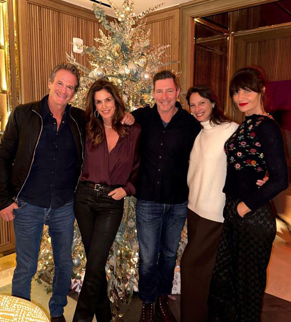 rande cindy edward christy and helena stand in line in front of a large silver christmas tree with cindy wearing a plunging purple satin blouse tucked into fitted black leather trousers as she stands with one hand in her pocket