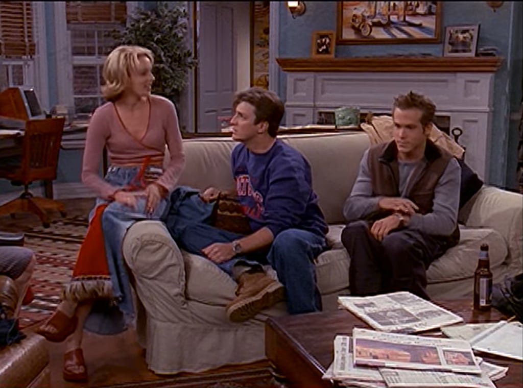 Nathan Fillion (C) and Ryan Reynolds (R) sit on a sofa in still from Two Guys And A Girl