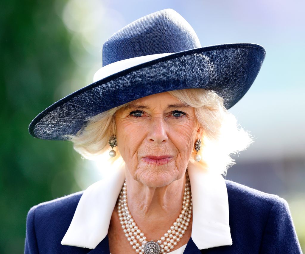 Queen Camilla in navy and white dress and pearls
