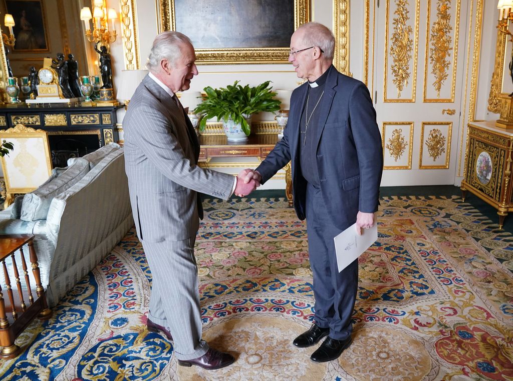 King Charles shaking the hand of the Archbishop of Canterbury inside the White Drawing Room