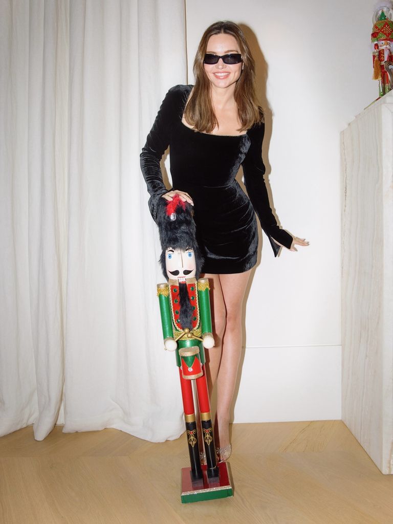 Miranda Kerr poses in a black velvet mini dress