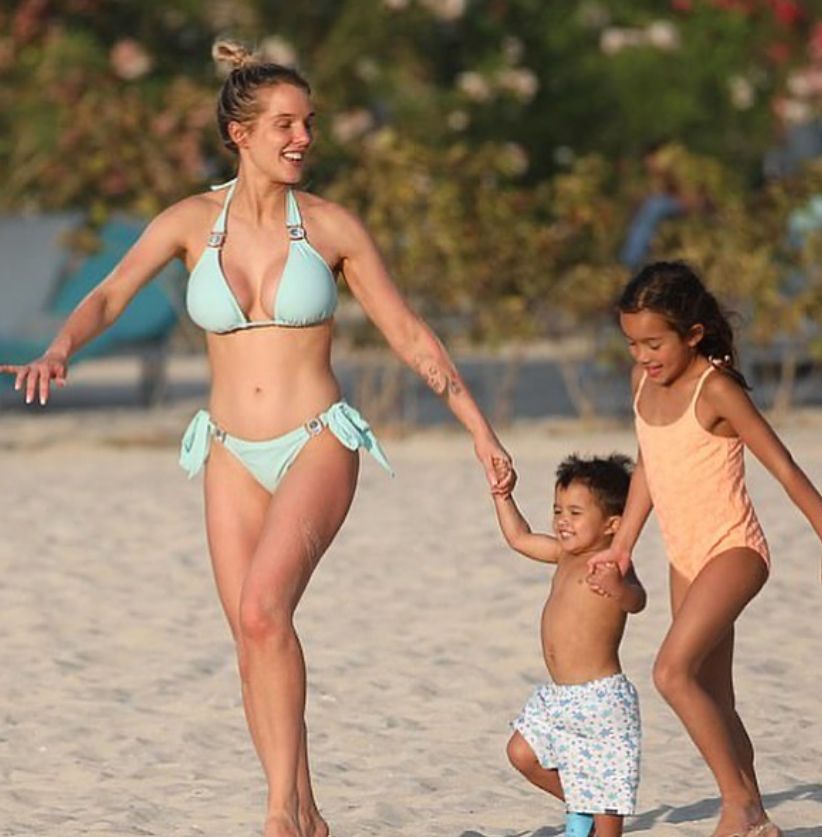 Helen Flanagan on a beach in a blue bikini with two of her children