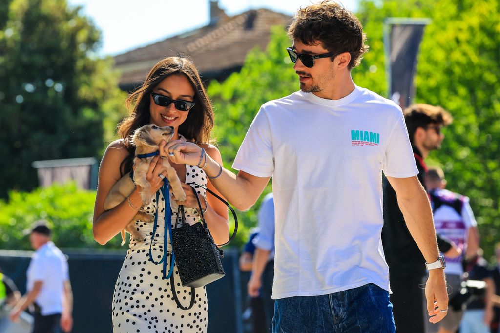 Charles Leclerc walking with Alexandra Saint Mleux, who is carrying a dog