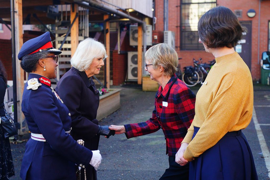 Queen Camilla shaking hands with a woman