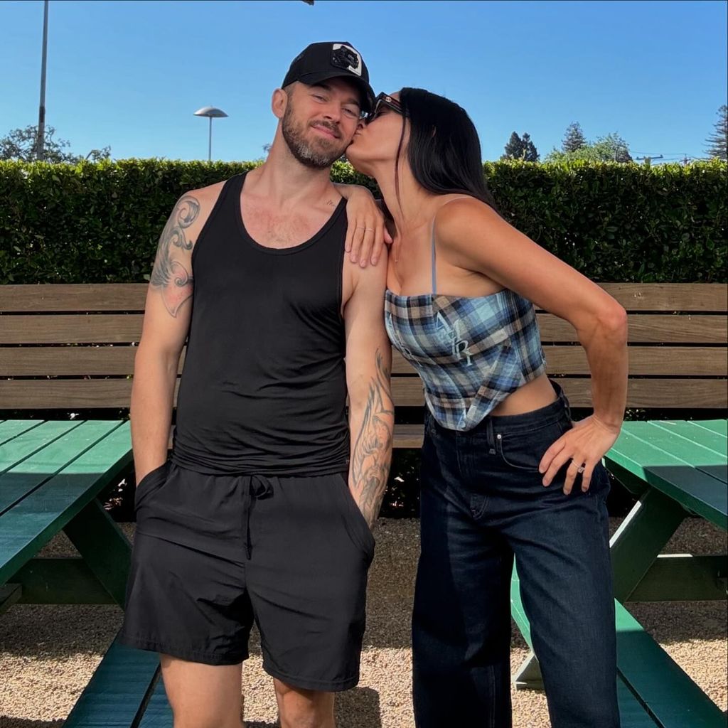 Nikki Bella kissing Artem Chigvintsev on the cheek