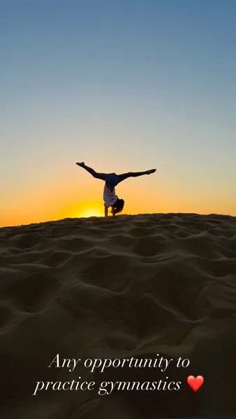 Amelia Andre doing a cartwheel on a sand dune 