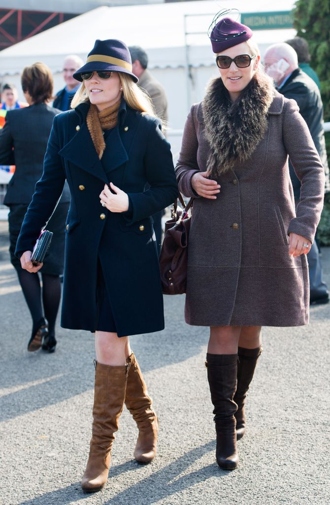 Autumn Phillips and Zara Tindall wearing coats and knee-high boots at Cheltenham
