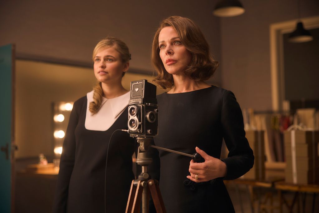 TWO WOMEN STANDING BEHIND FILM CAMERA