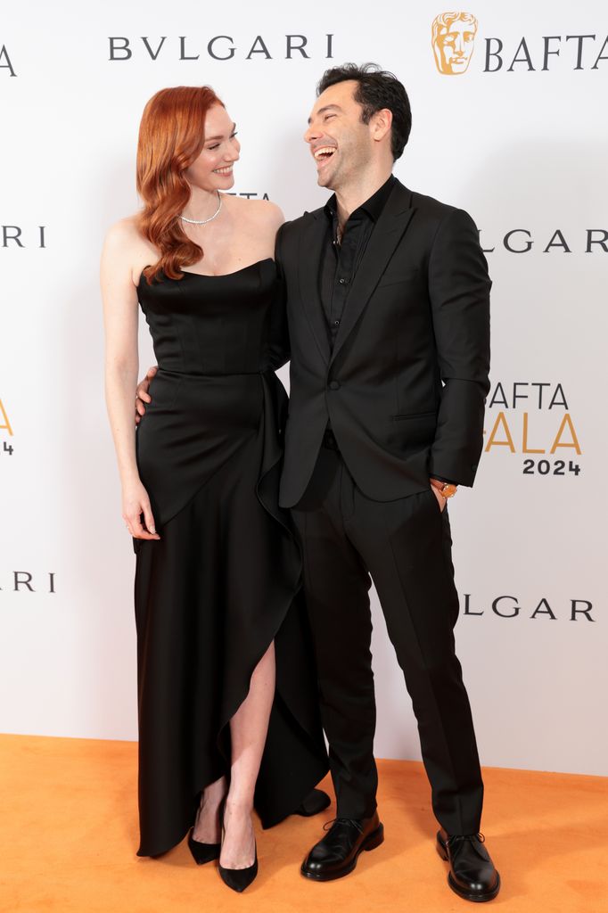 actors smiling on red carpet