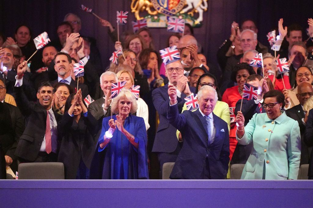 King Charles and Queen Camilla wave flags at coronation concert