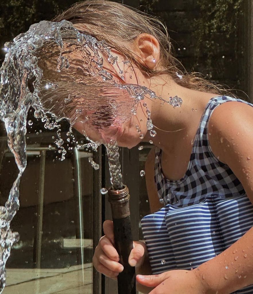 Khai played with the garden hose in a sweet summer snap