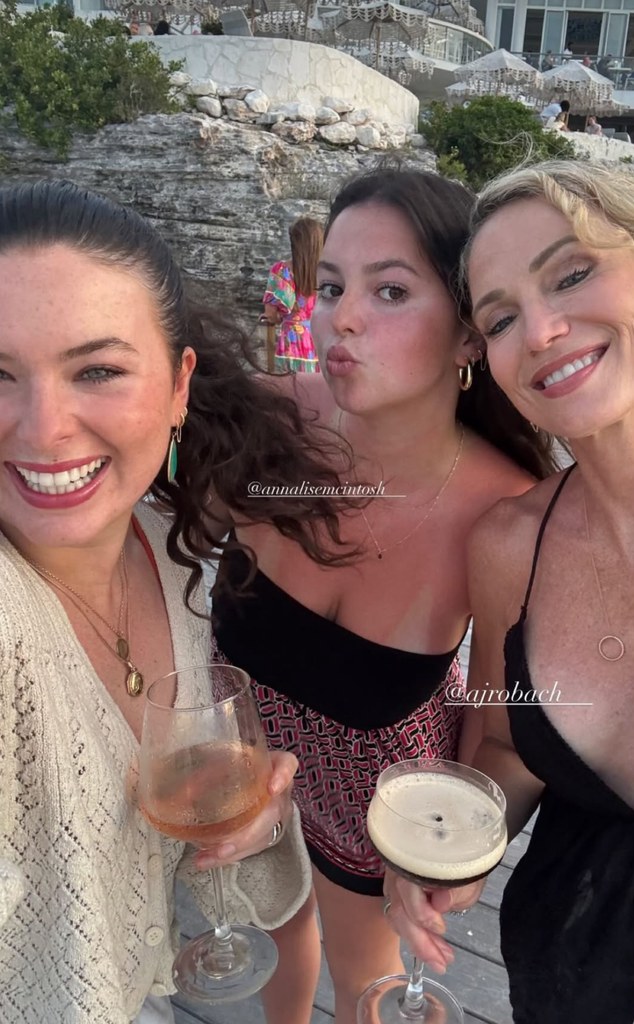 Amy poses for photos with her daughters on vacation holding cocktails