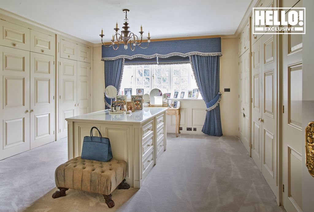 Yoanna Hanbury dressing room with beige floor to ceiling cupboards and island unit 