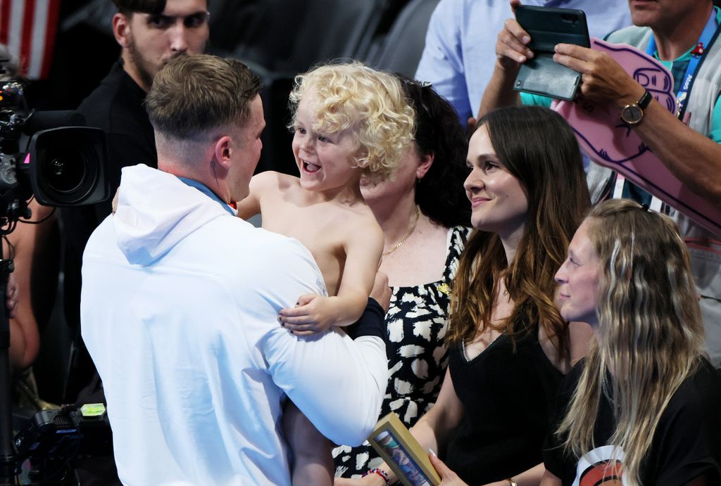 father hugging son at Olympics