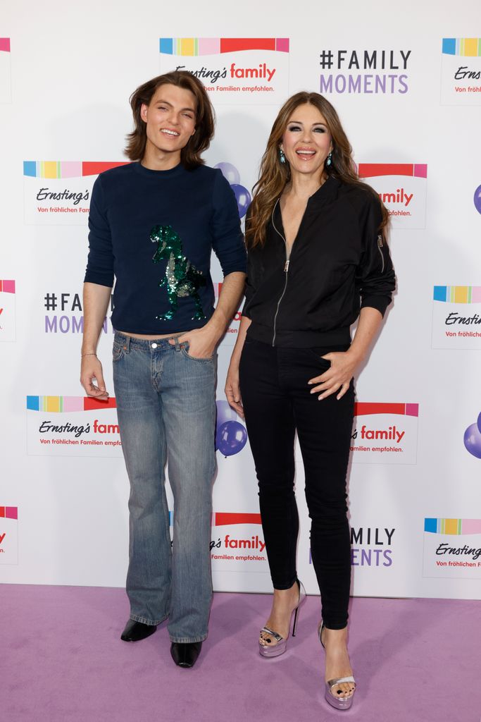 mother and son posing on purple carpet 