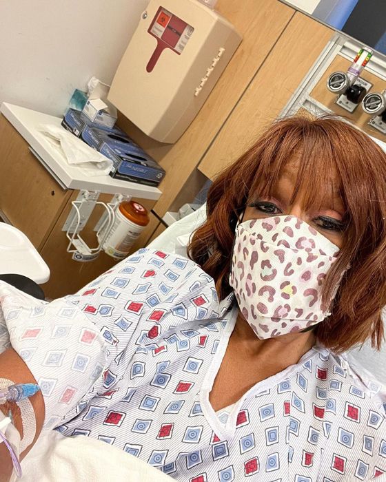 Gayle King in hospital wearing a mask and gown 