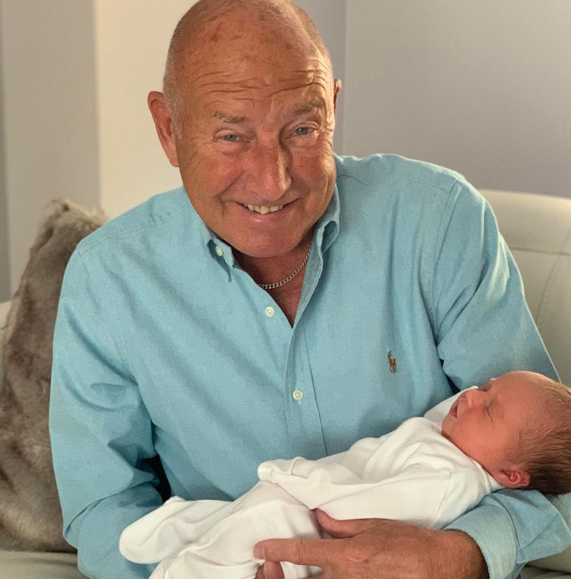 Elderly man holding a baby