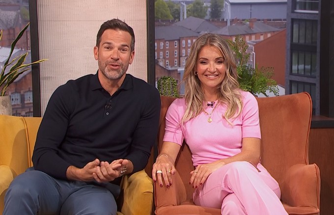 male and female tv hosts in tv studio on sofa