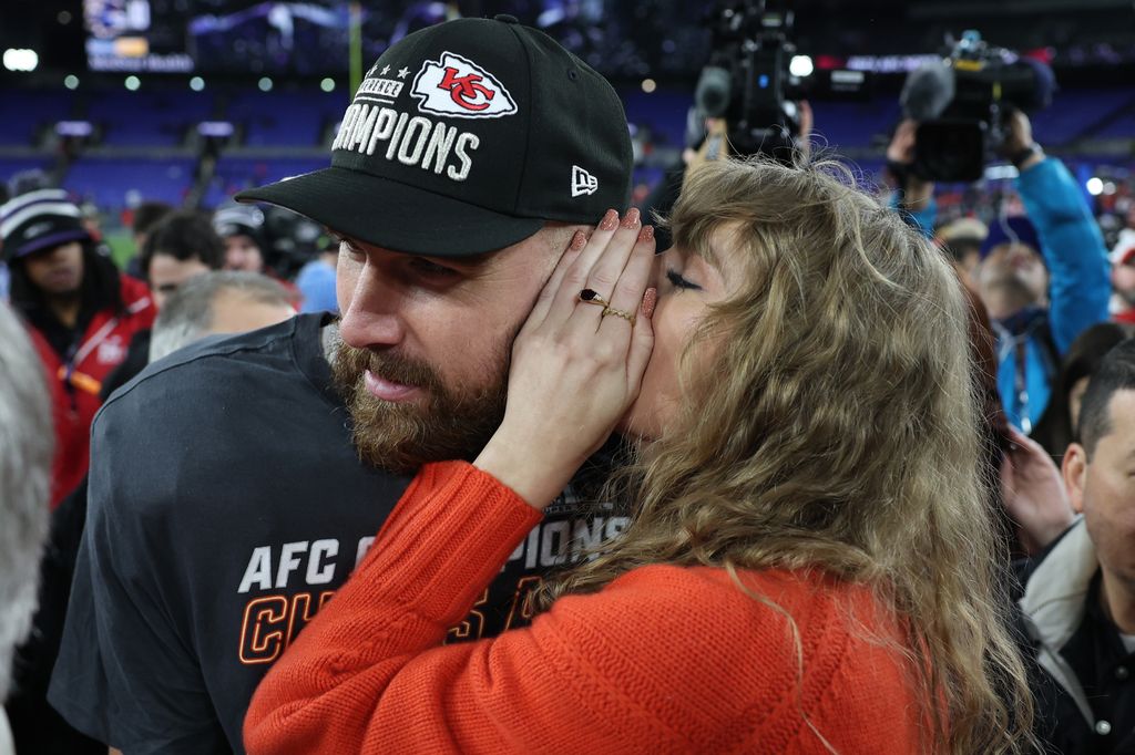 Taylor Swift whispering in Travis Kelce's ear
