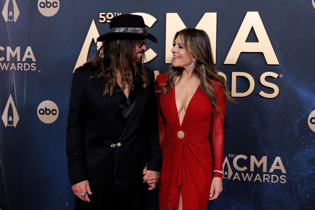 photo of billy ray cyrus and elizabeth hurley holding hands 2025 cmas