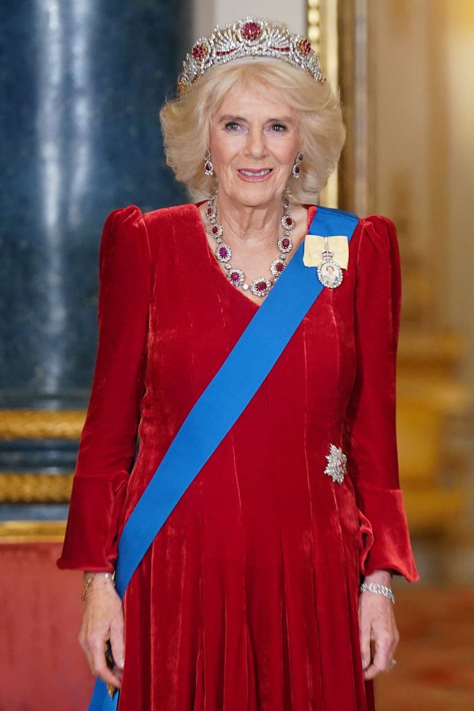 Queen Camilla in red velvet dress and ruby tiara