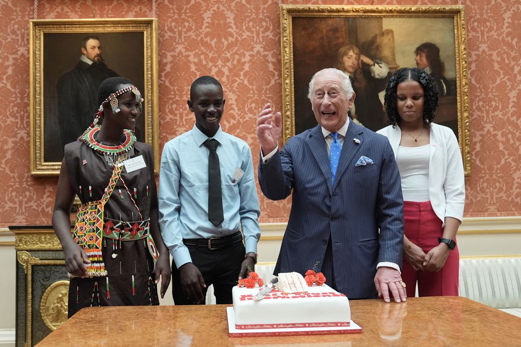 King Charles smiling by a cake
